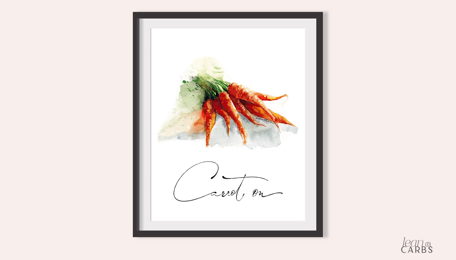 The Carrot On watercolor print in a black frame with a wide white mount, on a soft pink wall